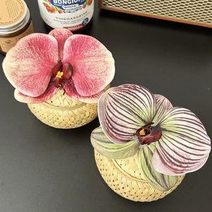 Detail of handcrafted bamboo boxes with pink and purple orchids for wedding favors