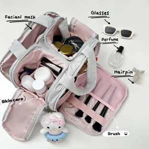Vue détaillée de la trousse de toilette grise avec doublure rose et compartiments variés