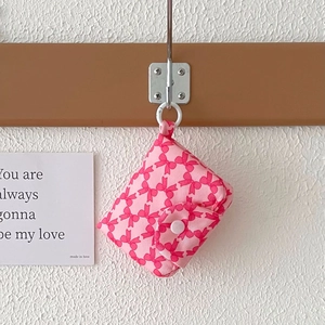 Close-up of pink fabric coin purse with red bow patterns and pink resin button clasp