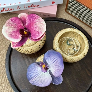 Detail of bamboo woven jewelry box with orchids on a vintage tray with jewelry