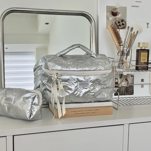 Silver metallic quilted cosmetic bag set with bow pattern and white ribbon details