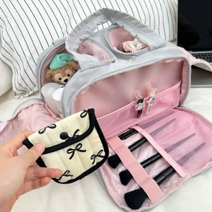 Vue détaillée de l'intérieur d'une trousse de maquillage grise et rose avec rangements