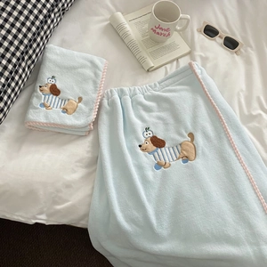 Close-up of cartoon dachshund embroidery and pink pom-pom trim on blue coral velvet towel
