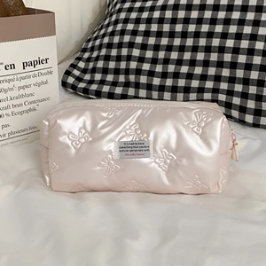 Nahaufnahme der rosa Schleifenprägung und des Reißverschlusses der Kosmetiktasche