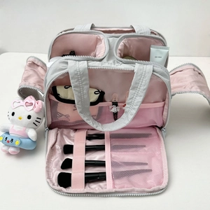 Vue détaillée de la trousse de maquillage grise avec intérieur rose et compartiments