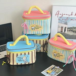 Detailed view of striped canvas makeup bags with cartoon bear and sturdy carry handles