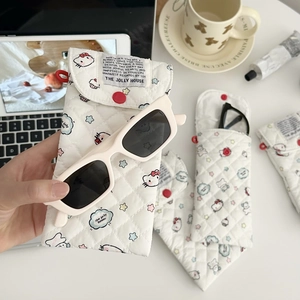 Detailed view of quilted cartoon cat eyewear pouch with red button on white background
