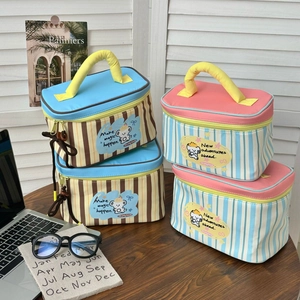 Detail of cartoon puppy stripe lunch bag showing dual zippers and yellow handle