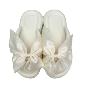 Women's chunky platform flip flops with oversized white silk bow detail and soft sole