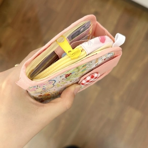 Vue détaillée du mini porte-monnaie floral avec liseré rose et fentes pour cartes multiples