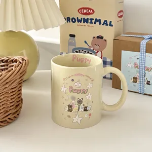 Close-up of cream ceramic mug featuring cute puppy illustrations and pink puppy text