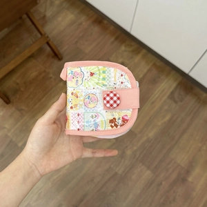 Détail du porte-monnaie en tissu rose avec oursons de dessin animé et bouton