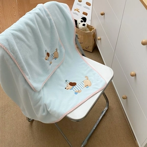 Detail of soft blue coral fleece towel with pink piping and cute embroidered cartoon dog