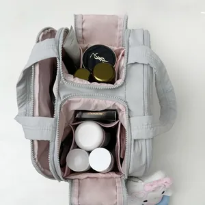 Vue détaillée du grand sac cosmétique gris avec compartiments de rangement roses