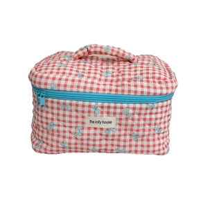 Red plaid quilted cosmetic bag with blue bow prints and top handle on white background