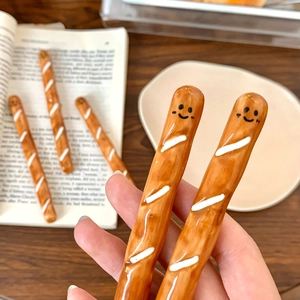 Close-up of cute baguette shaped ceramic coffee stirrers with smiley face design