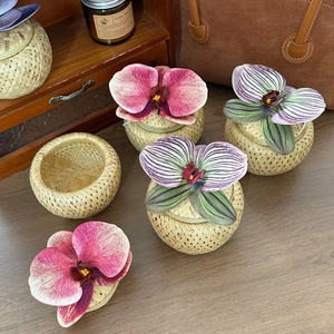 Detail of woven bamboo gift boxes decorated with exquisite orchid flowers in home setting