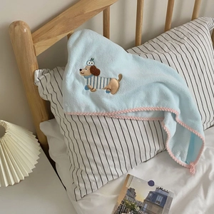 Detail of light blue towel with cute dog embroidery and pink wavy scalloped edges