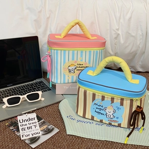 Detail of colorful striped cosmetic bags with bear prints and soft yellow handles