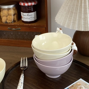 Detail of ceramic bowls with relief cat figurines in soft purple and cream white tones