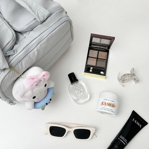 Vue détaillée d'une trousse de maquillage grise matelassée avec charms et produits