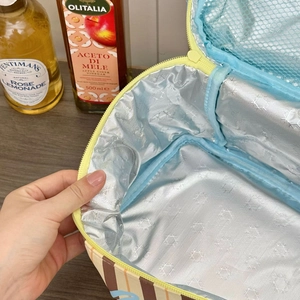 Detail of insulated lunch bag showing silver aluminum foil lining and interior mesh pocket