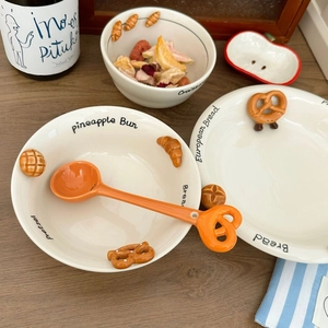 Detailed close-up of ceramic bowl set with 3D embossed bread designs on wooden table
