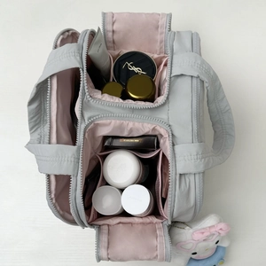 Détails de la trousse de maquillage avec doublure rose et compartiments de rangement