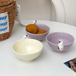 Detailed view of lavender and cream ceramic bowls with 3D cat relief and smooth glaze finish