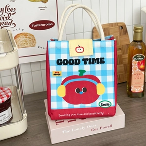 Detail of insulated lunch bag with red apple print and thick cord handles in kitchen setting