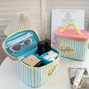 Blue striped makeup bag with yellow handle and compartments for travel cosmetics