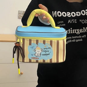 Close-up of portable striped lunch bag featuring cartoon koala and durable handle