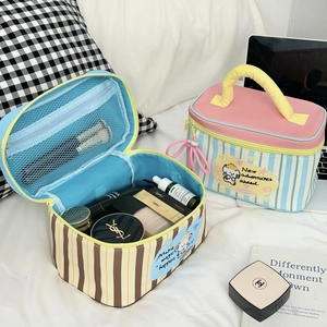 Detail view of the striped dog makeup bag showing internal mesh pocket and blue lining