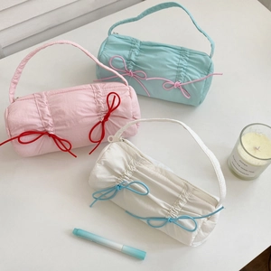 Detail view of colorful bow pencil cases in pink, blue and white with pleated nylon fabric
