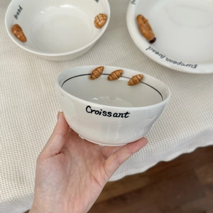 Detailed view of ceramic croissant relief bowl with embossed bread design and text