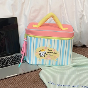 Close-up of pink lid and blue striped lunch bag with a cute cartoon dog illustration