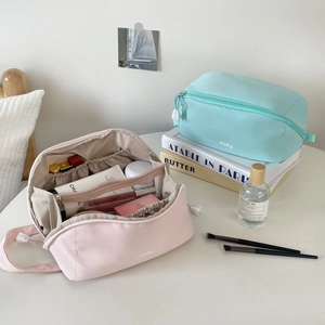 Detail view of pink makeup bag interior with elastic slots and multiple compartments