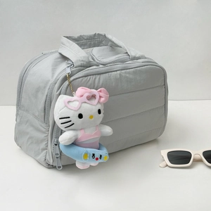 Vue détaillée d'une trousse de toilette matelassée grise avec pendentif en peluche