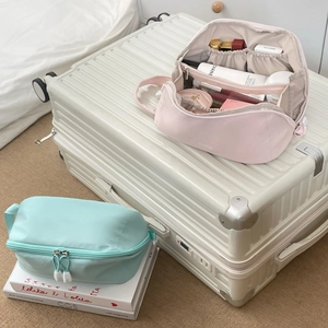 Detail of pink and green travel cosmetic bags with elastic slots and large interior capacity