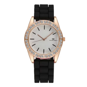 Detail of rose gold rhinestone bezel and white dial with black silicone strap