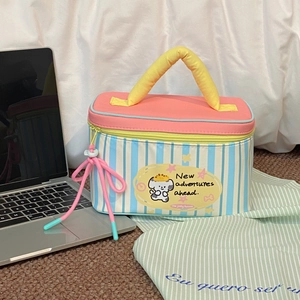 Detail of blue striped dog makeup bag with yellow handle and pink drawstring charm