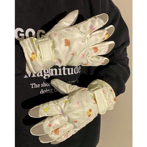 Detail of cream winter gloves with cartoon prints, anti-slip fingertips and velcro strap