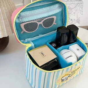 Detail view of the blue striped cosmetic bag showing spacious interior with mesh pockets