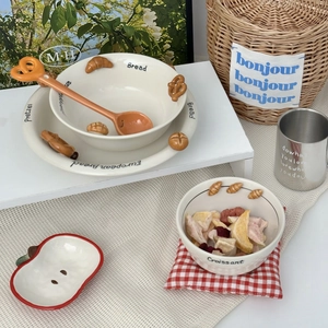 Detail view of cream ceramic tableware set with 3D croissant and pretzel embossing