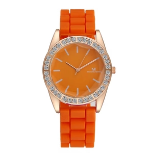 Detailed close-up of rose gold watch with rhinestone bezel and orange silicone strap