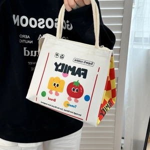 Close-up of canvas lunch bag with cartoon bread prints and red plaid side panels