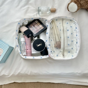 Detail of white polka dot makeup bag showing large capacity and mesh brush compartment