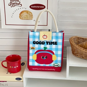 Detail of insulated lunch bag featuring blue checkered pattern and cute apple graphics