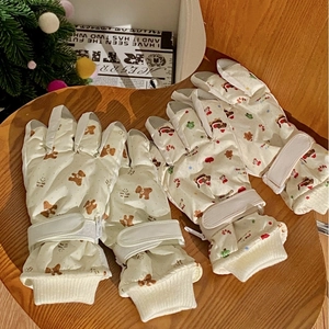 Detail of thermal winter gloves with cartoon bear and Santa motifs for outdoor cycling