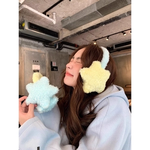 Cute yellow and blue star-shaped plush earmuffs for winter outdoors worn by a model